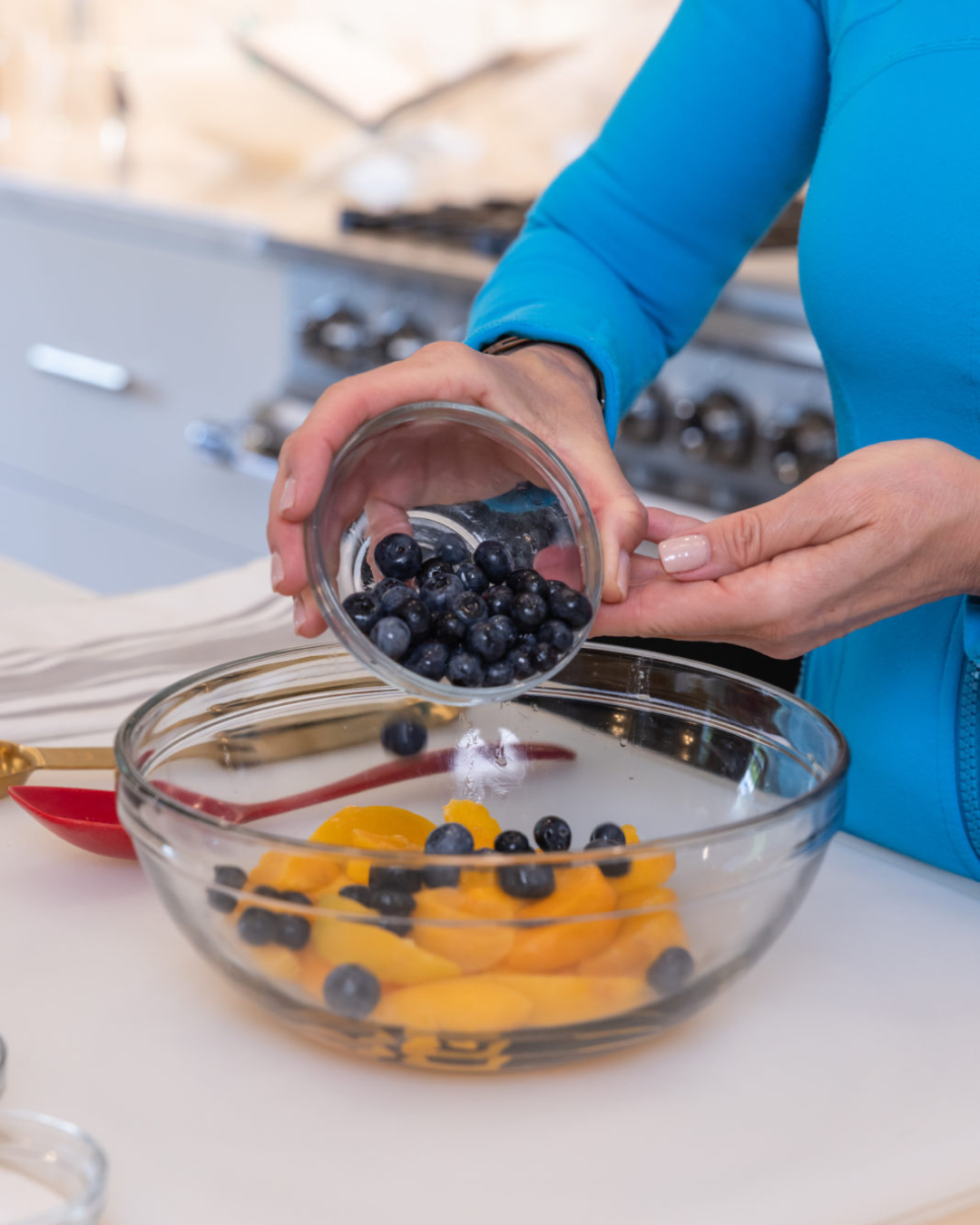 tiffany pouring blueberries into a bowl with the peaches, the perfect dessert for peach season